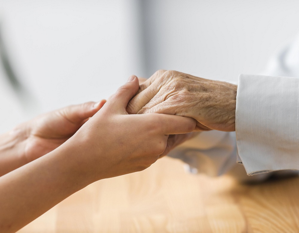 personnel infirmier tenant la main personne âgée pour la réconforter dans sa maladie